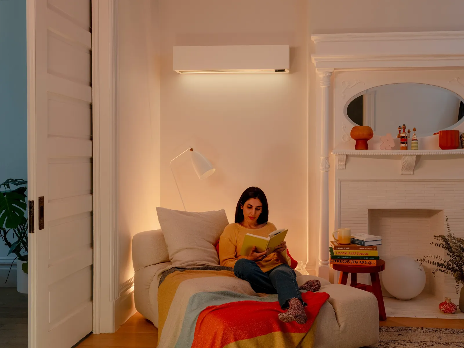 Woman in orange sweater sitting on a cozy beige couch