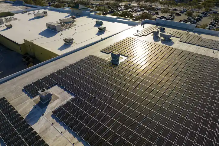 Aerial view of a commercial building roof covered with solar panels, showcasing photovoltaic system installation for energy efficiency in El Cajon, CA.