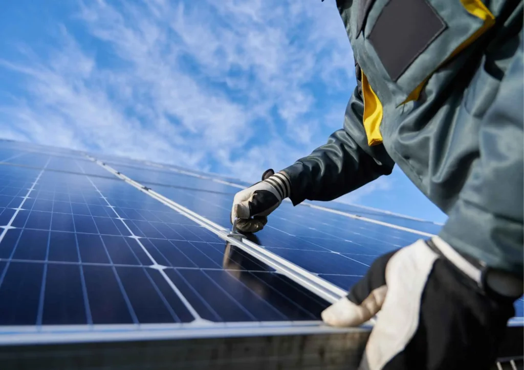 Person adjusting solar panel during installation or maintenance under a clear blue sky, emphasizing solar energy solutions and system upgrades in Chula Vista.