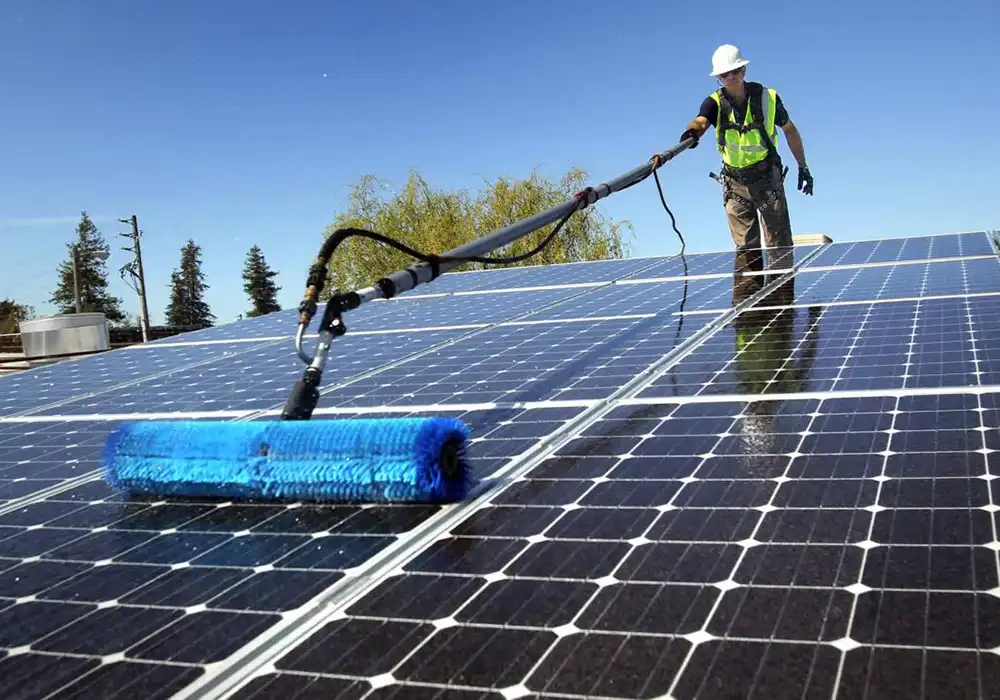Worker cleaning solar panels on a rooftop in Santee, showcasing solar energy maintenance for sustainable home energy solutions.