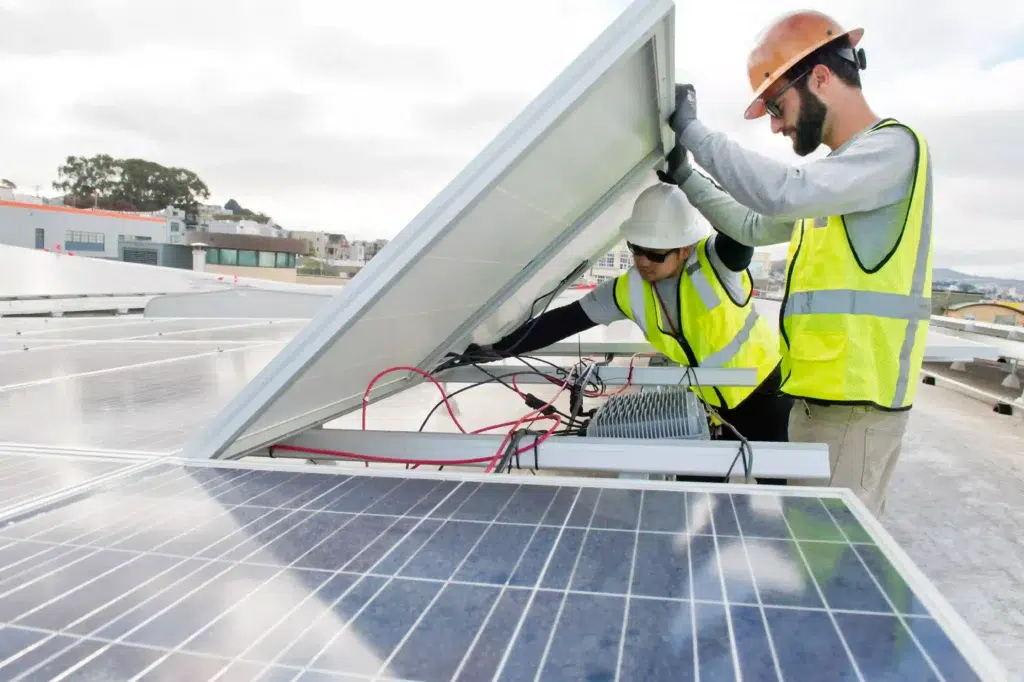 Technicians performing solar panel maintenance, inspecting and adjusting equipment on a rooftop in Chula Vista, emphasizing professional care for solar energy systems.