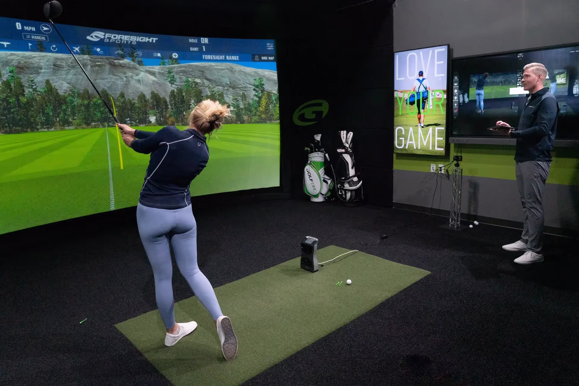 Practicing golf swing in GOLFTEC Center hitting bay