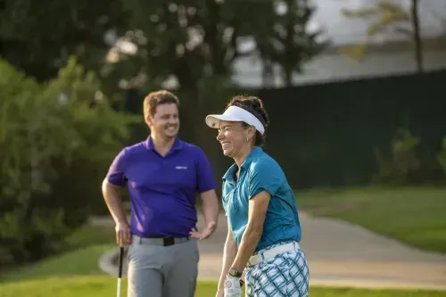 Golf instractor with student on drivinf range during a golf lesson.