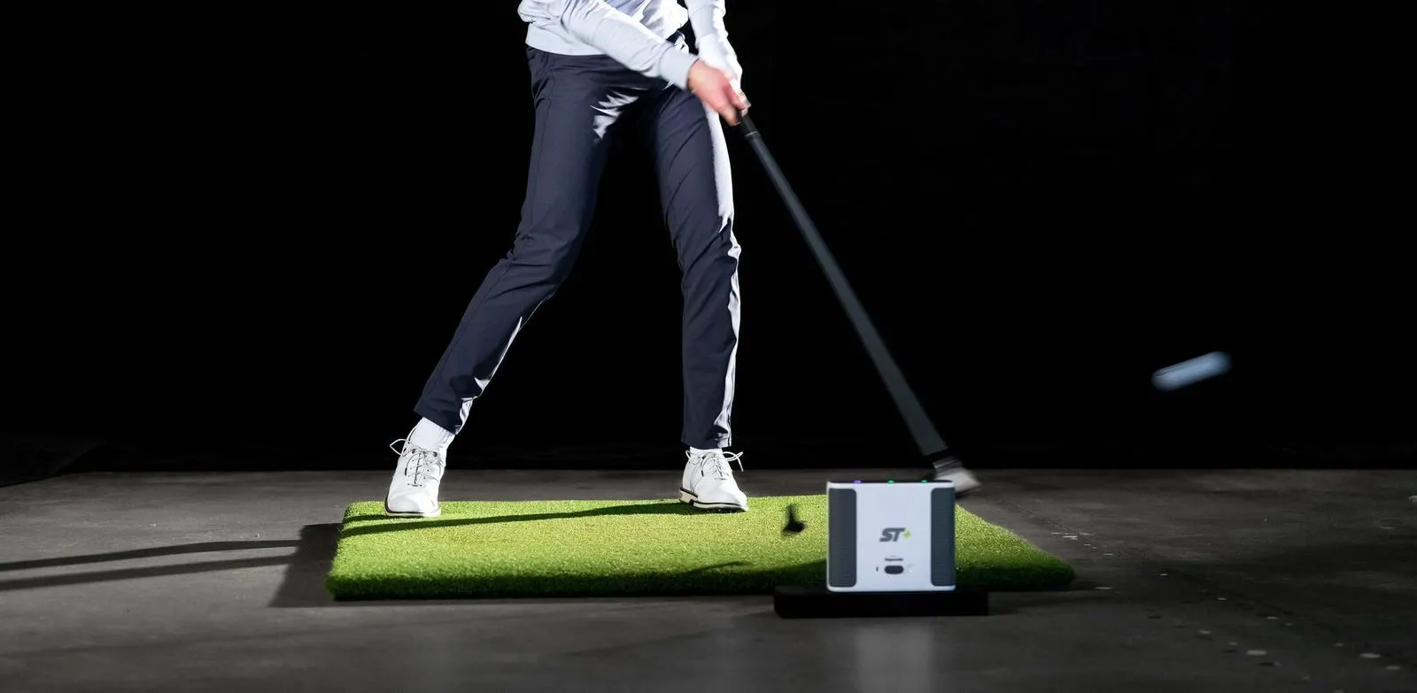 Golfer hitting driver on golf simulator powered by Skytrak+ launch monitor
