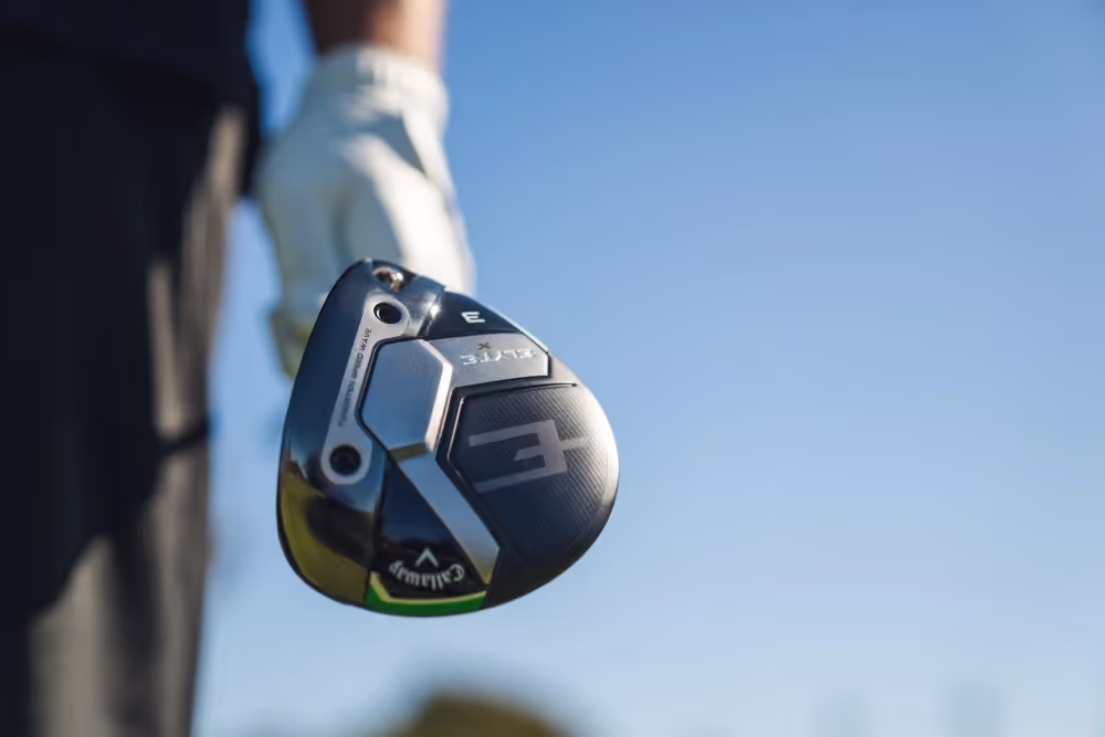 Close-up of a golfer holding a Callaway driver with a sky background. 