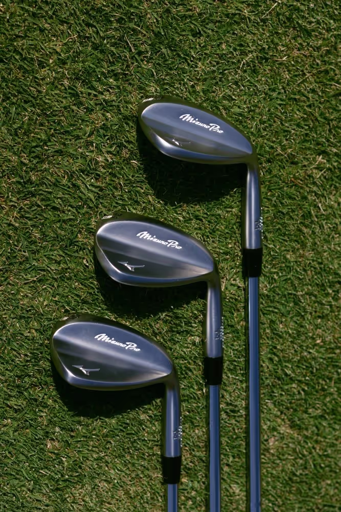 Three Mizuno Pro-T1 wedges laying on the course, with a refined black finish, highlighting their design.
