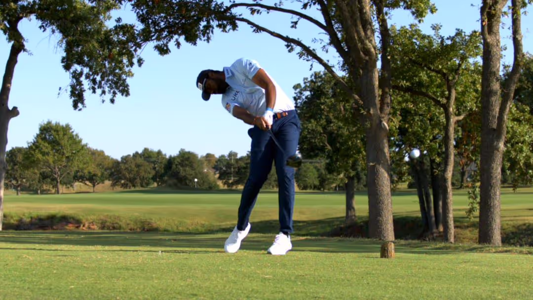 Golfer swinging a PING club on the course 