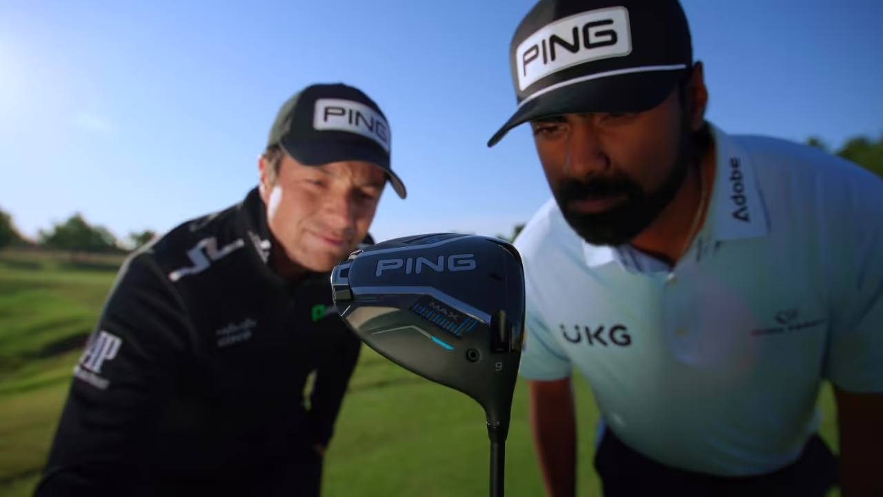 Viktor Hovland and Sahith Theegala, wearing PING hats, check out a new PING driver on the golf course 