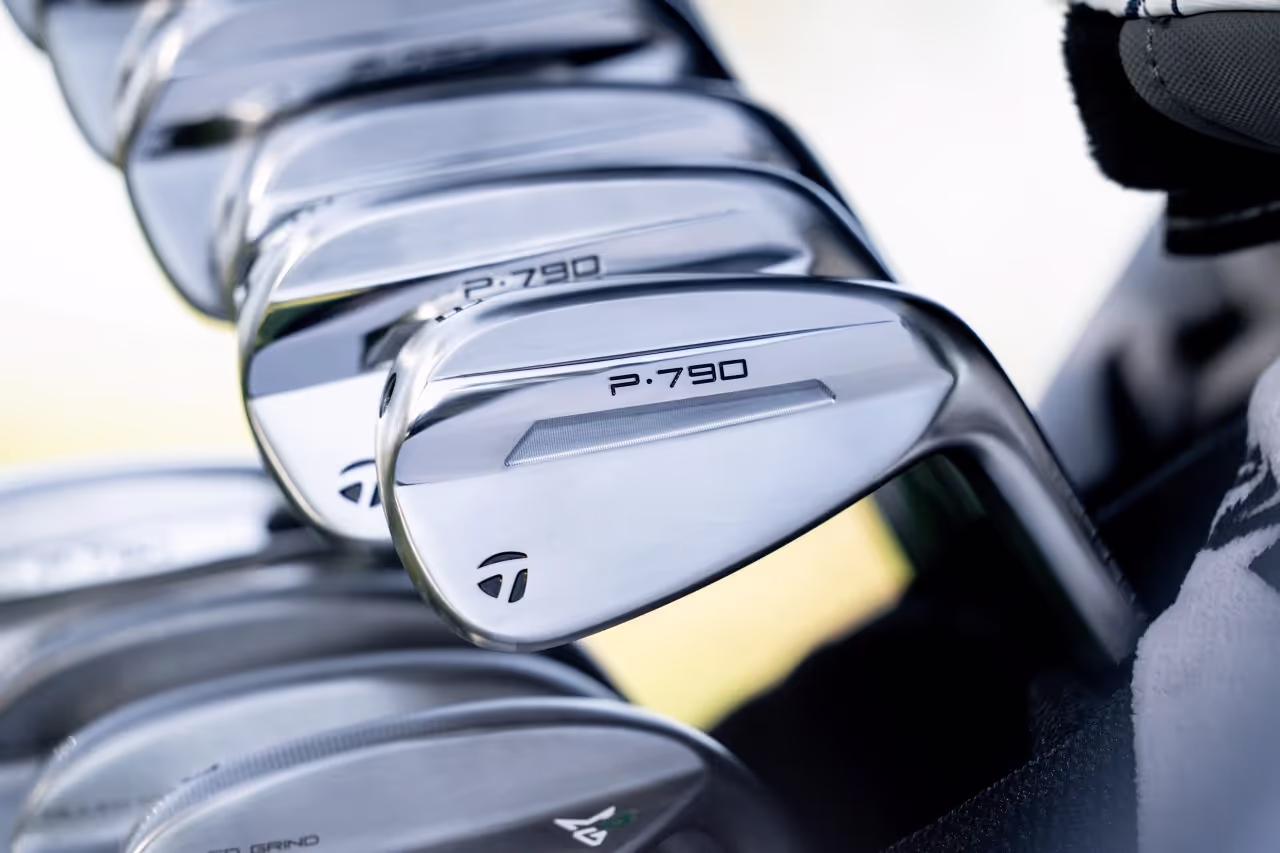 Close-up view of TaylorMade P970 irons in a golf bag, showcasing the clubheads. 