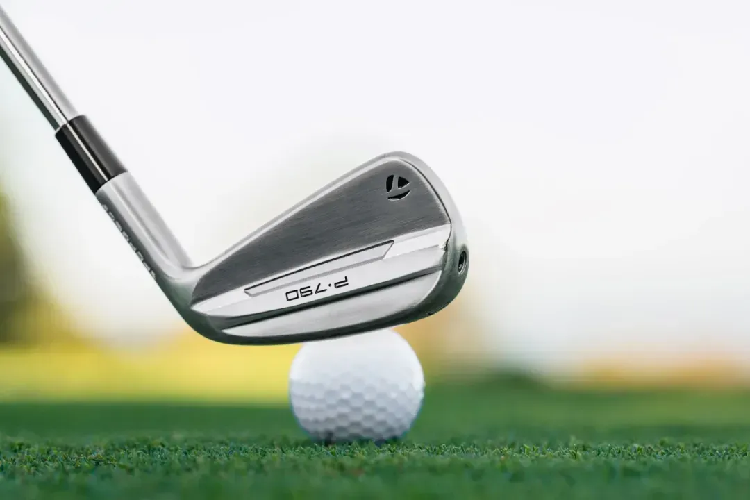 TaylorMade P970 iron lined up on the course, ready to hit the golf ball. 
