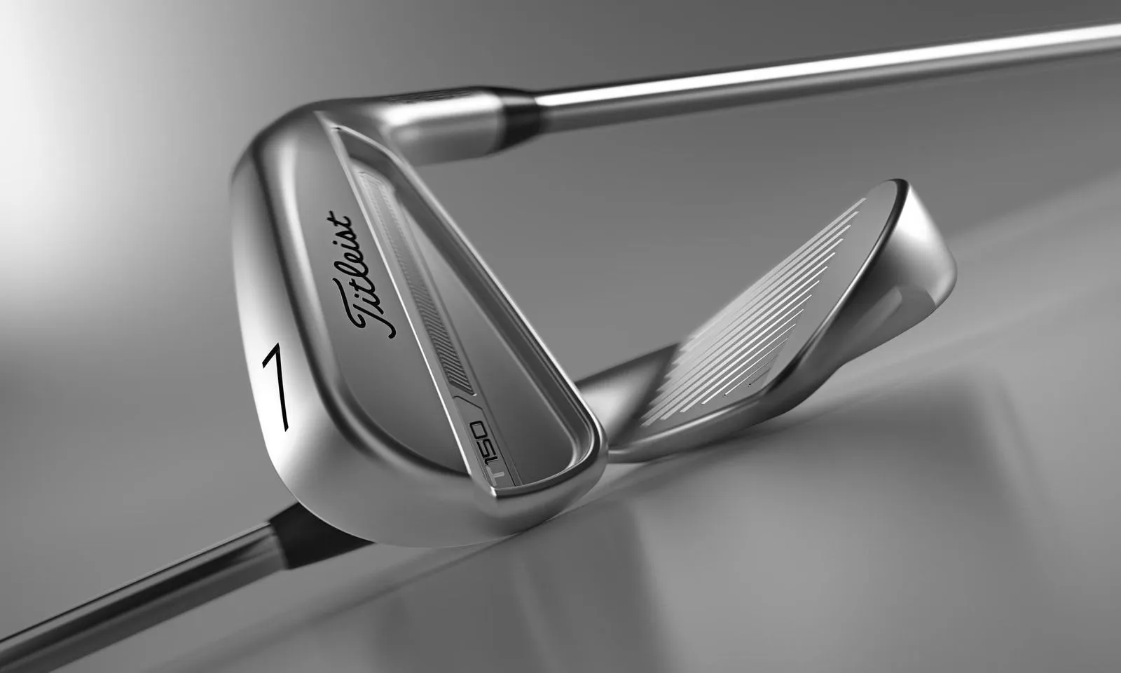 Two Titelist T150 Irons on a grey background. 