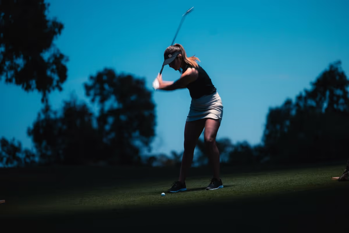 Golfer swinging the Callaway Paradym Ai Smoke Irons, hitting the ball on the golf course. 
