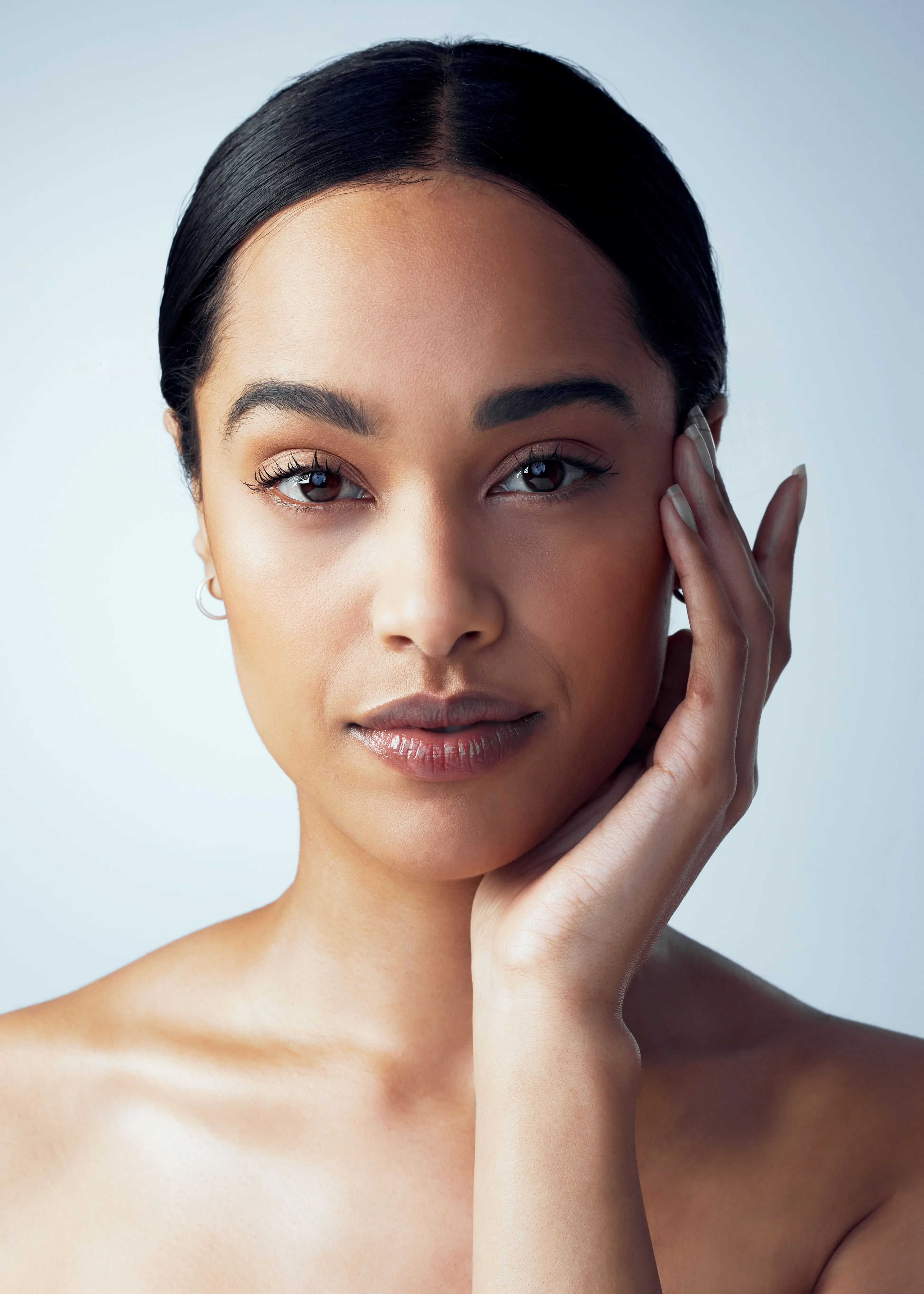 A woman posing for a picture with her hand on her face.