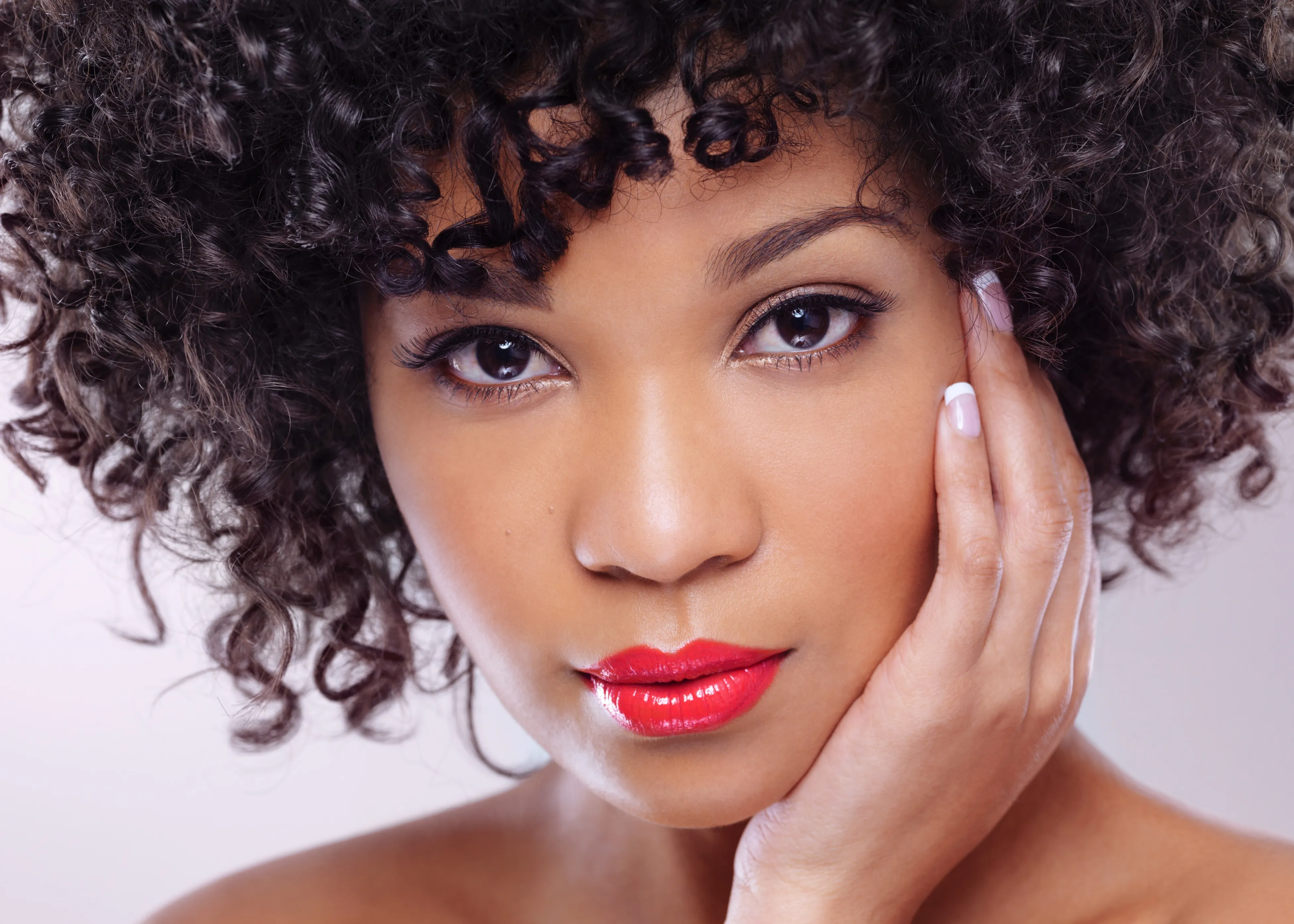 A close up of a woman with curly hair.