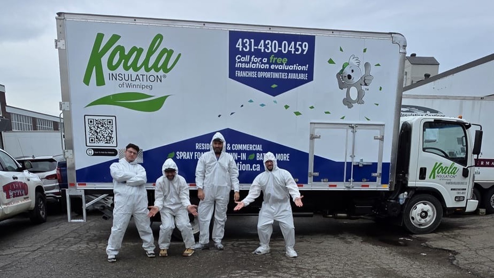 Koala Insulation of Winnipeg crew in PPE standing in front of the branded company truck