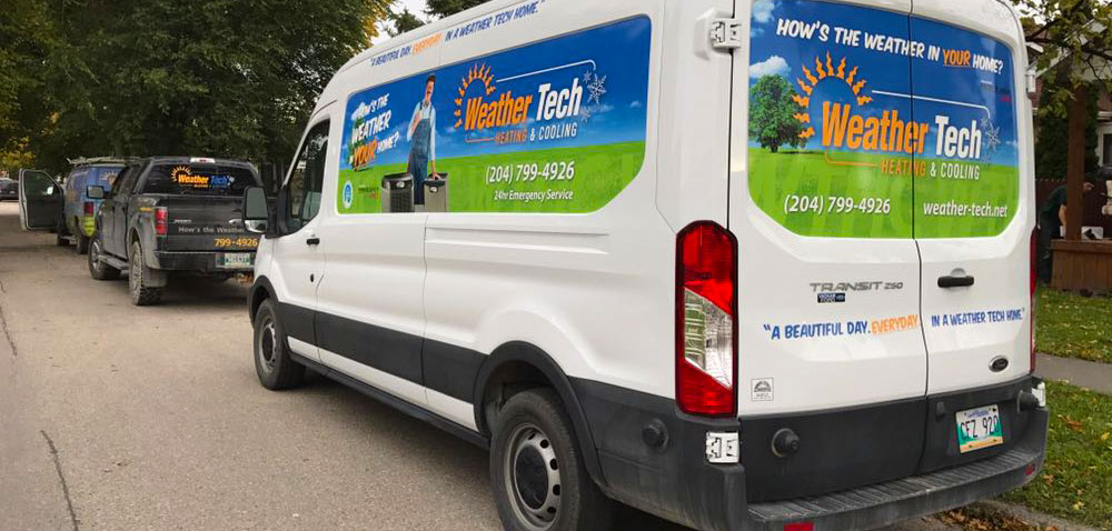 Weather Tech Heating & Cooling branded service vans parked on a residential Winnipeg street
