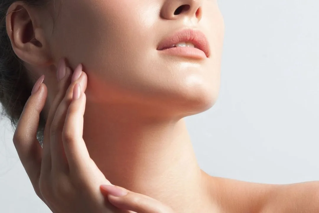 A woman with her hand on her neck.