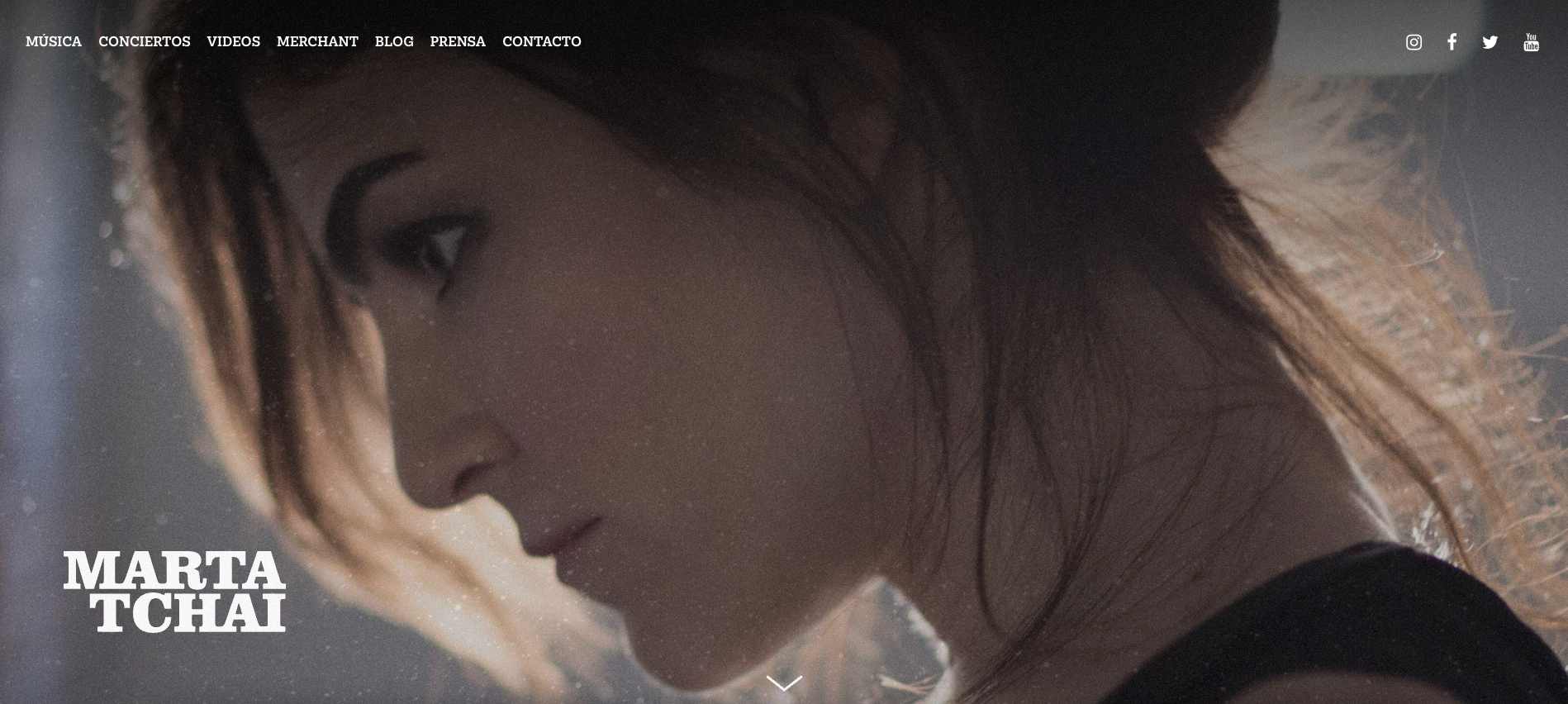 A screenshot of Marta Tchai’s website, featuring a full-screen portrait of the artist. Large white text reads, “Marta Tchai,” and an arrow points down to urge visitors to scroll further.