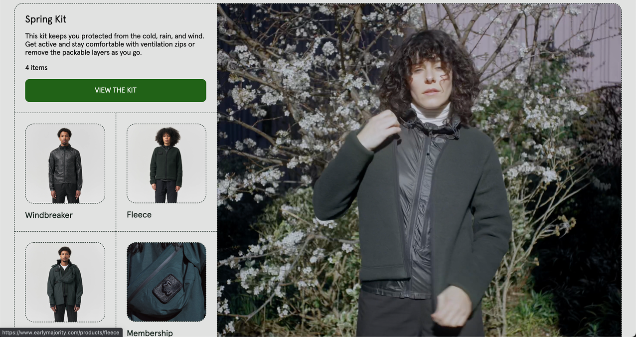 A snippet of the Early Majority's product detail page for its "Spring Kit," featuring a curly-haired model on the right donning the apparel. The left side of the page features a green "View the Kit" CTA button and smaller thumbnail images of the windbreaker, fleece, and more offered in the kit.