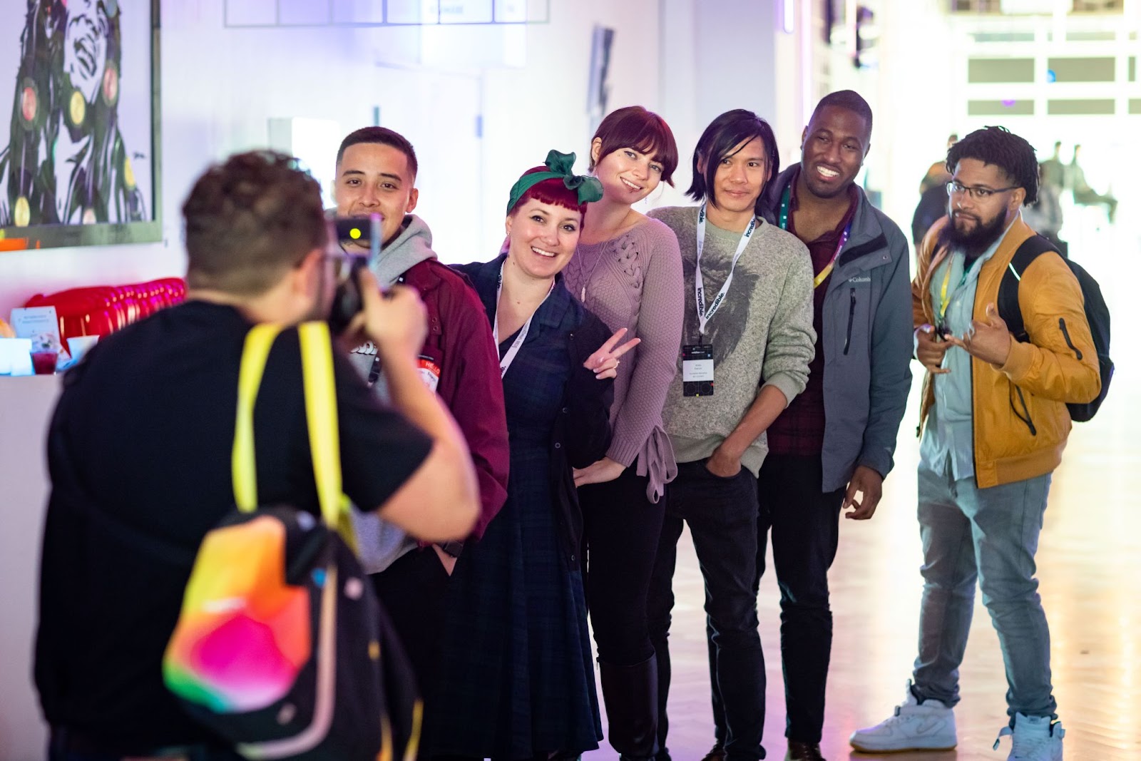 A group of six people smile while a photographer takes their picture.