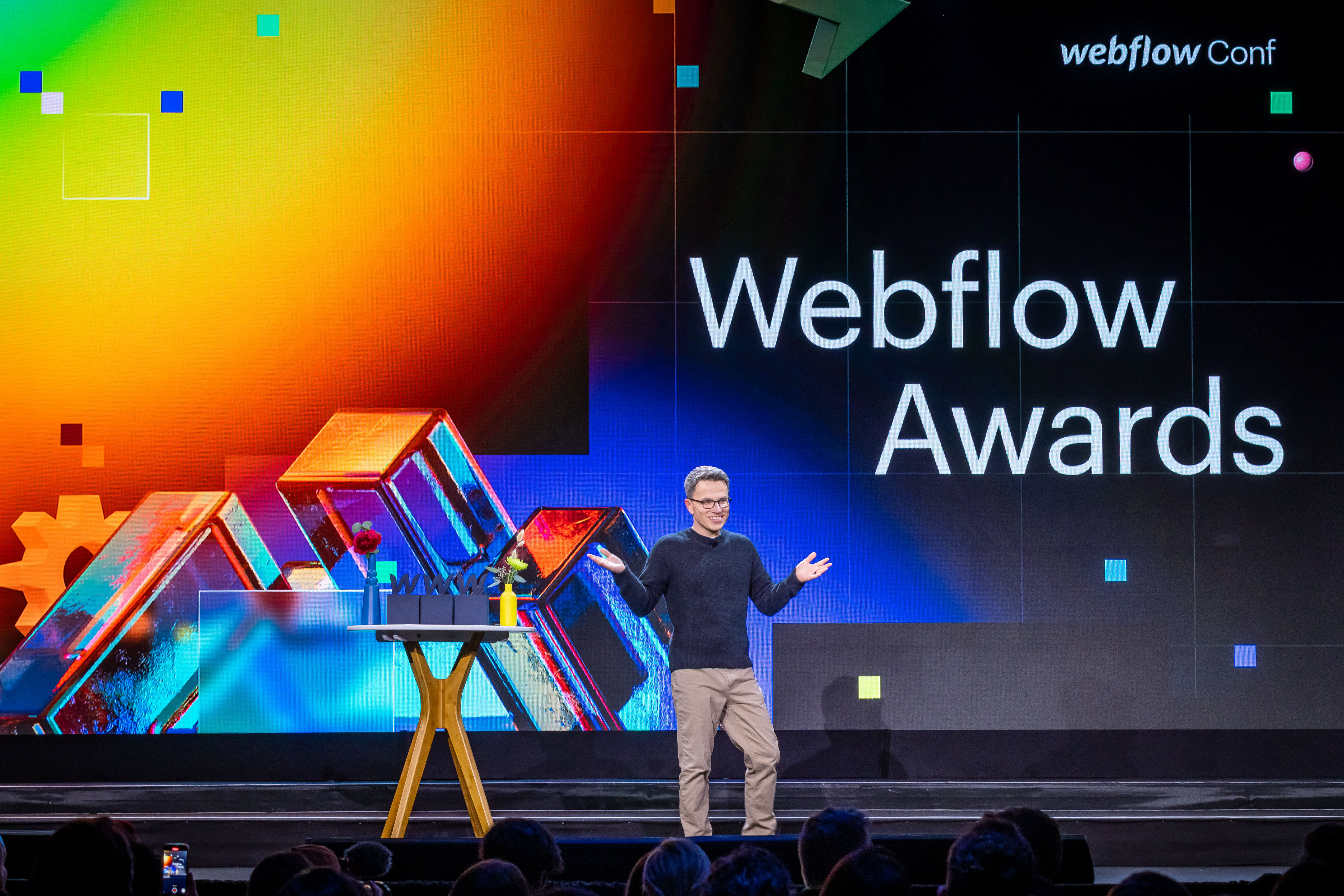 Vlad Magdalin on stage at Webflow Conf 2022. The word "Webflow Awards" is projected behind him.