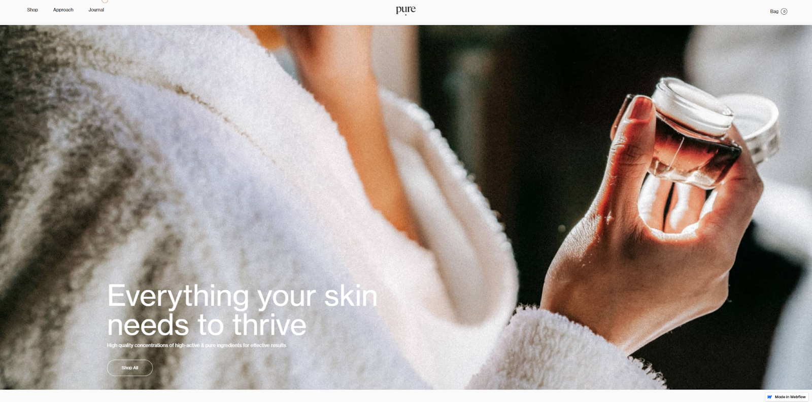 The Pure Cosmetics homepage overlays the headline “Everything your skin needs to thrive” on an image of someone holding a jar of face cream.