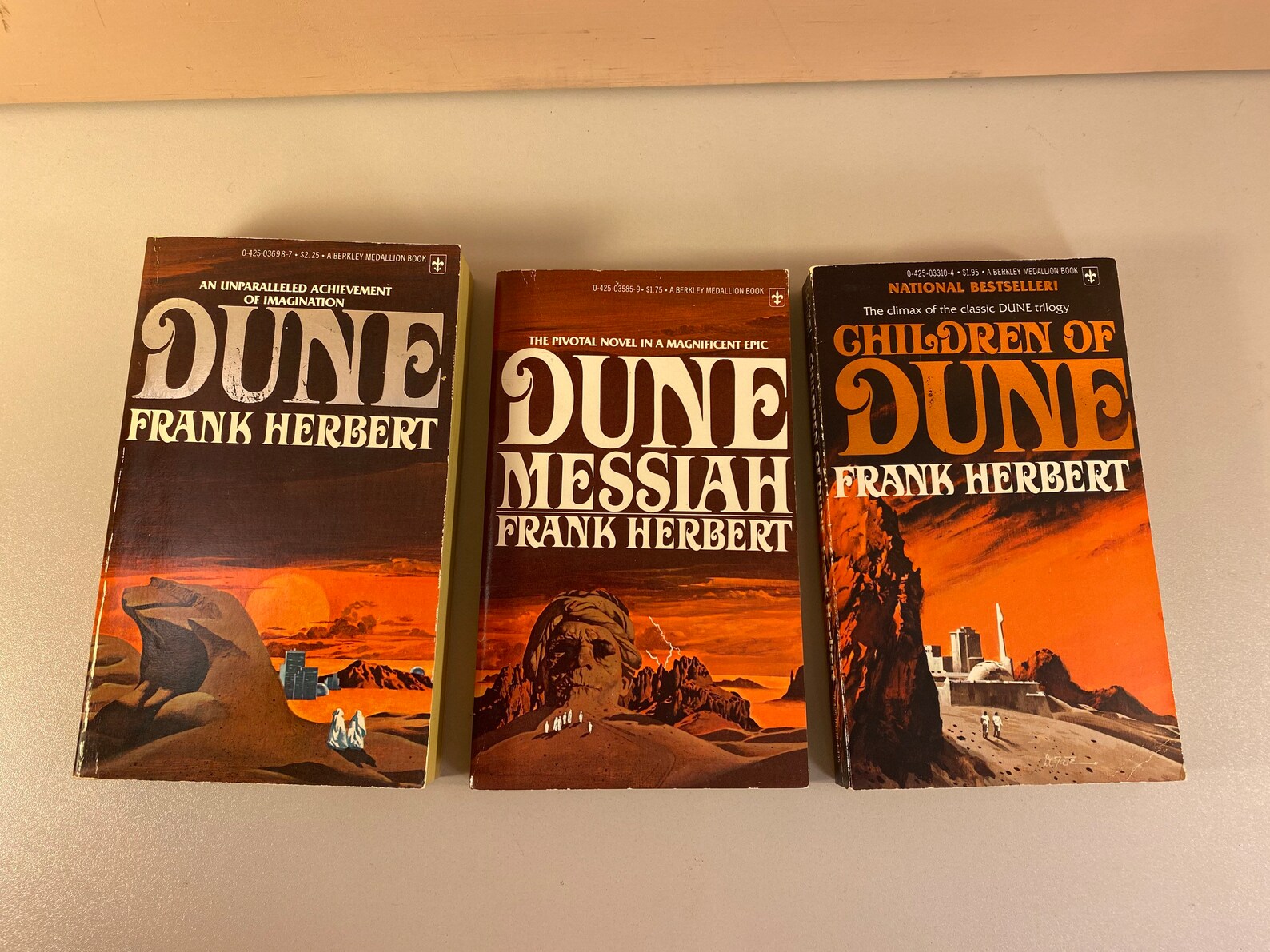 Photo of three paperback books, the Dune trilogy by Frank Herbert
