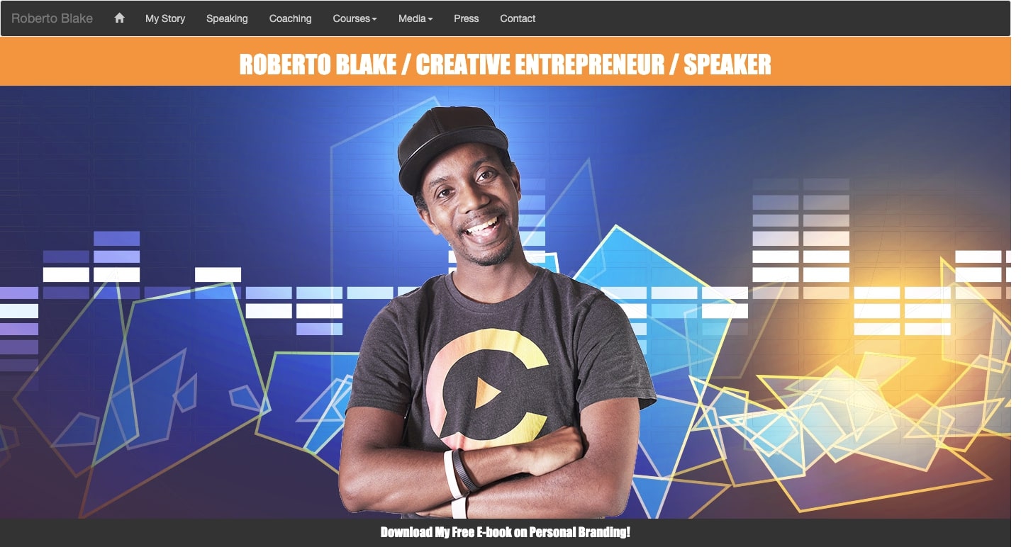 Roberto Blake homepage. Blue background with geometric shapes in shades of blue and white. Photo of Roberto in black t-shirt, smiling and crossing arms.