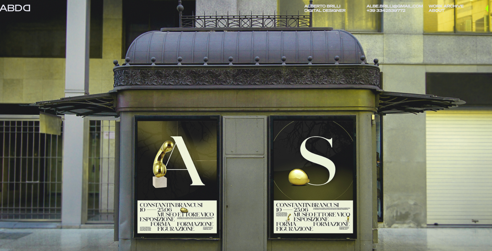 Photo of two art exhibition posters on the exterior of an ornate Italian building.