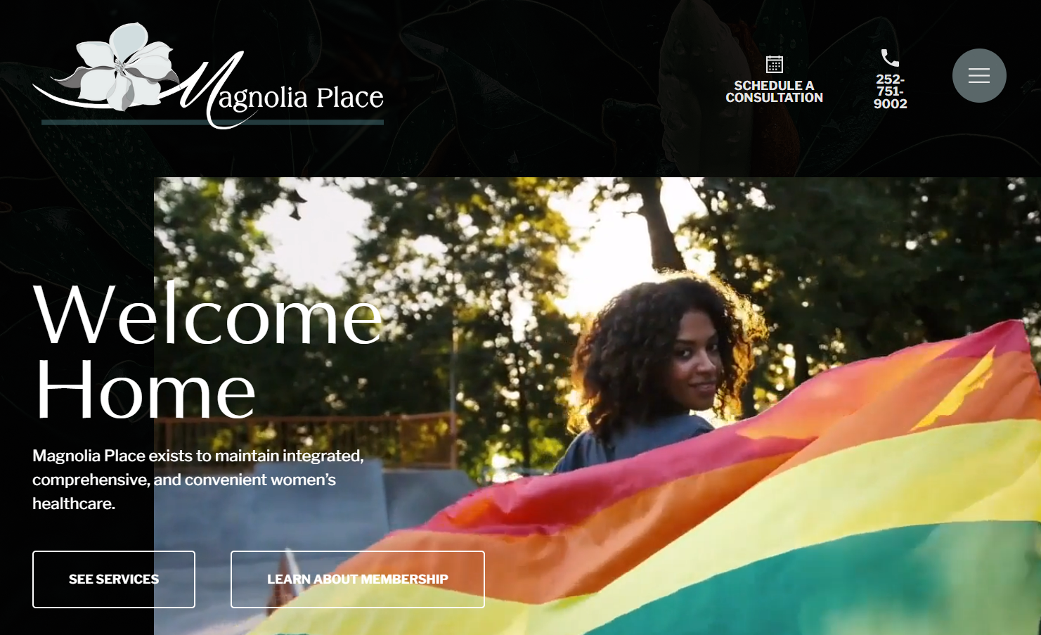 Magnolia Place homepage with text saying “Welcome Home” and a woman carrying a rainbow flag behind her while she looks back.