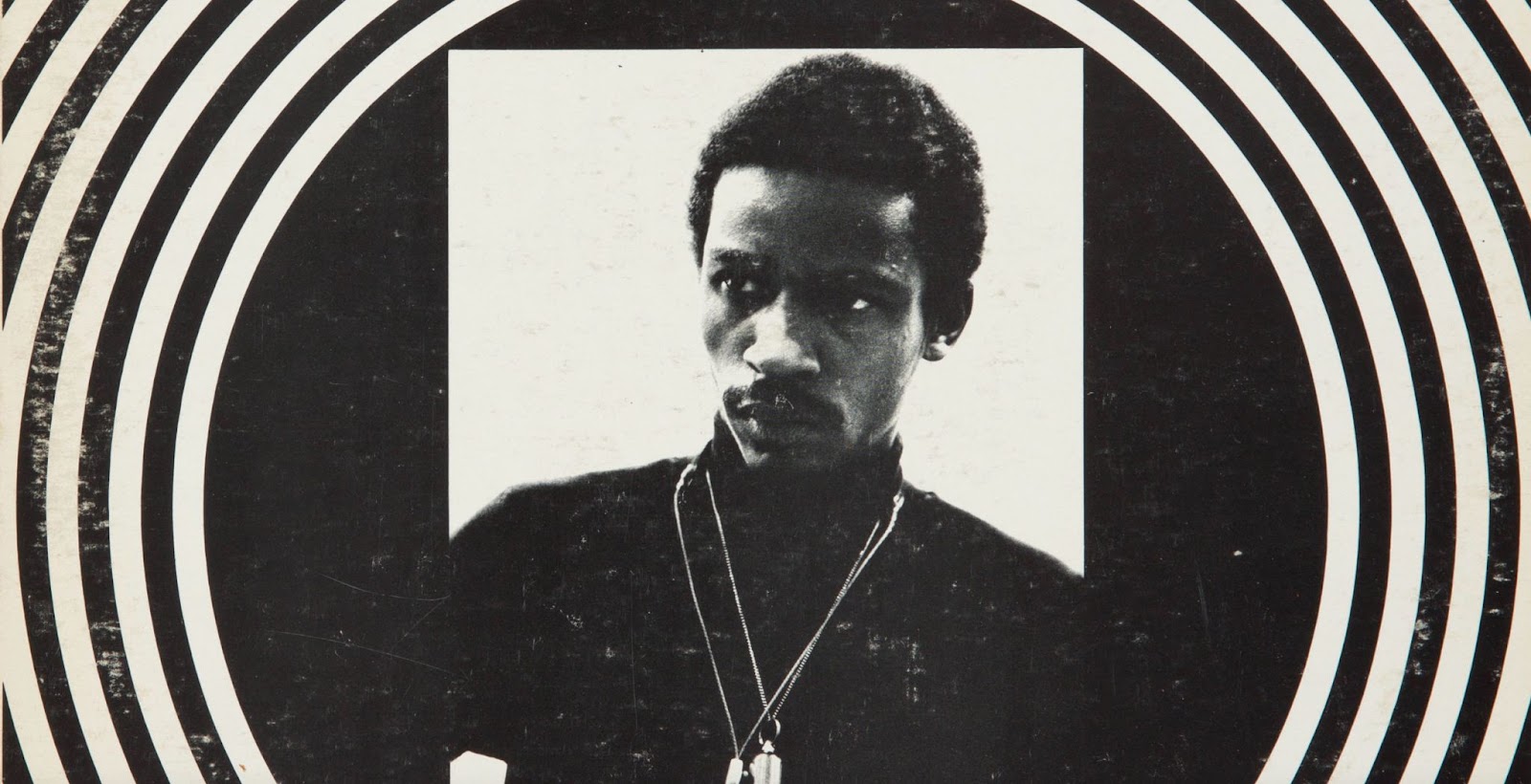The album cover for Sound, by the Roscoe Mitchell Quartet. The central image is a black and white photo of a man in a black turtleneck wearing two necklaces staring off into the distance. Surrounding the image is alternating black and off-white rings.
