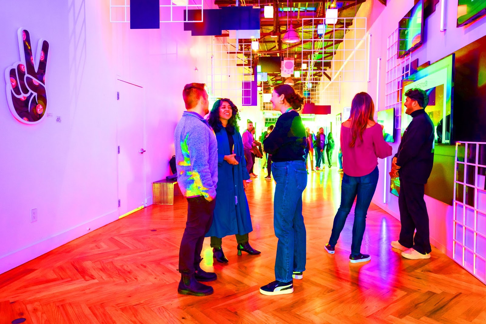 An image of attendees standing and talking at Webflow Conf 2022. This picture was made more saturated so all of the colors appear more vibrant.t