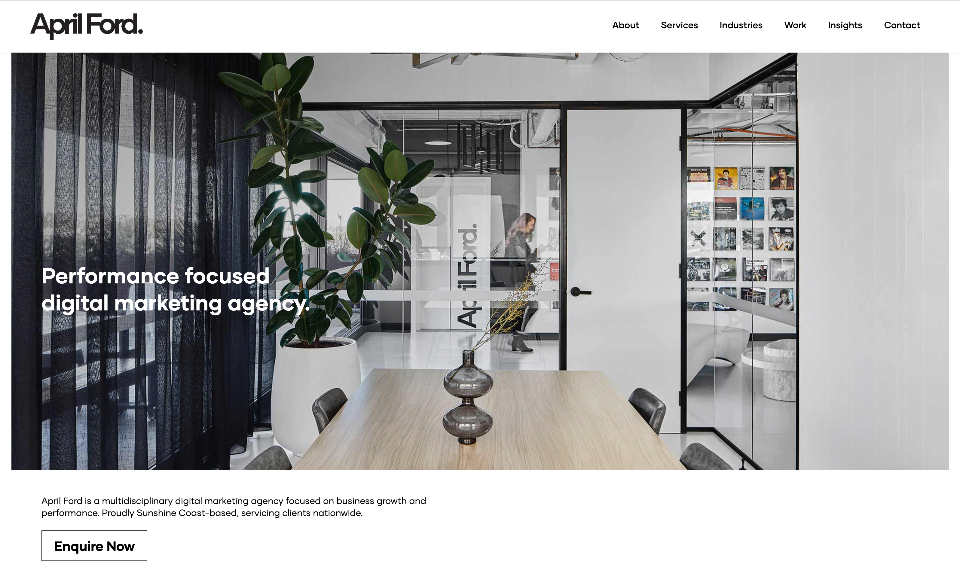April Ford homepage. Image of women in office with floor-to-ceiling glass doors takes up entire page under a text menu.