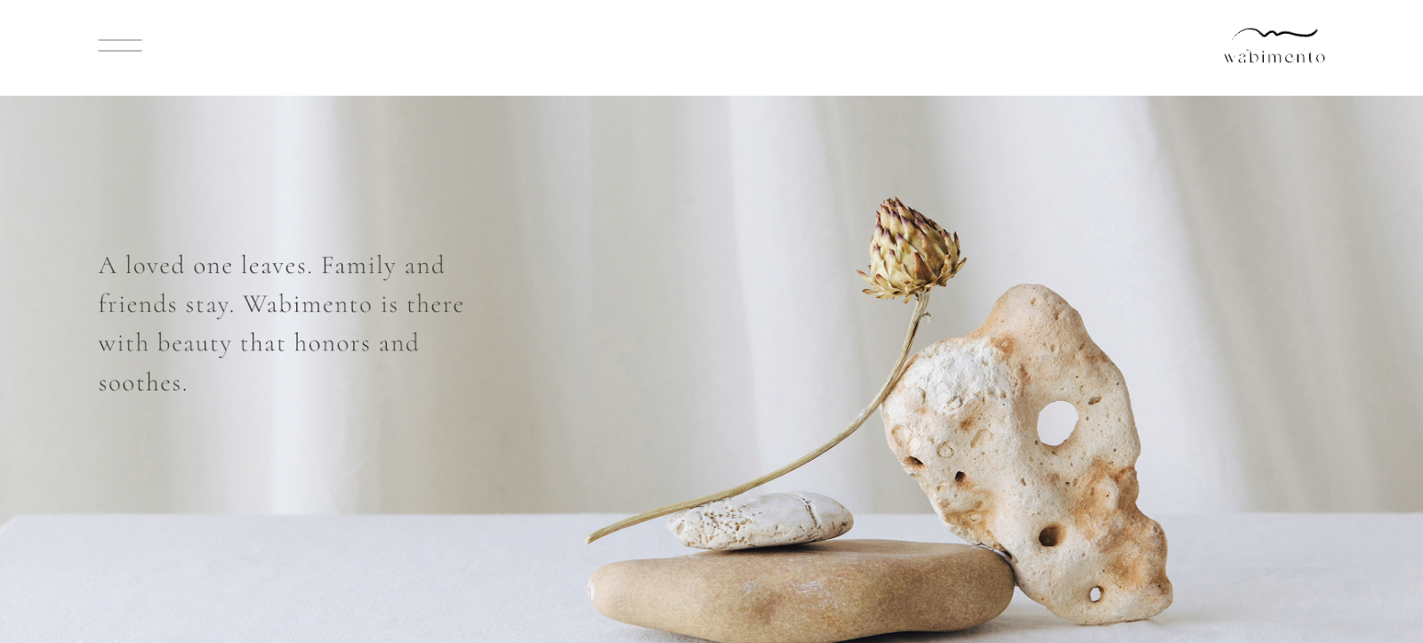Funeral services website homepage featuring a softly colored photo of stacked stones and a dried flower.