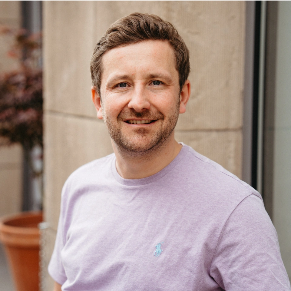 Alexander Hahn lächeln in einem lavendel-farbenen T-Shirt