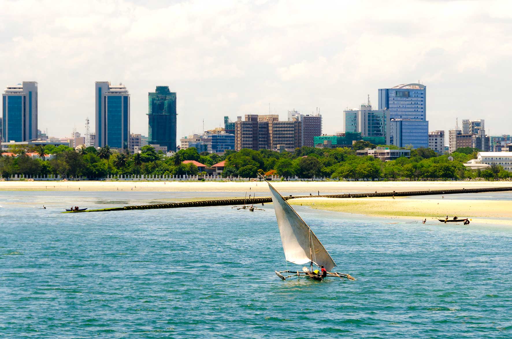 Image of a Tanzanian coastline with a business district in the background.