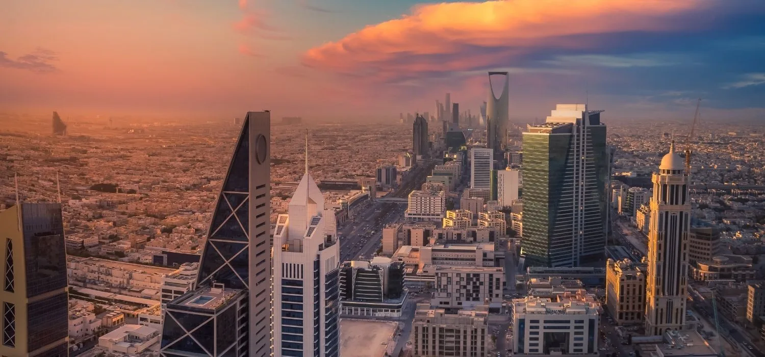 A cityscape of business buildings in Saudi Arabia at dusk.
