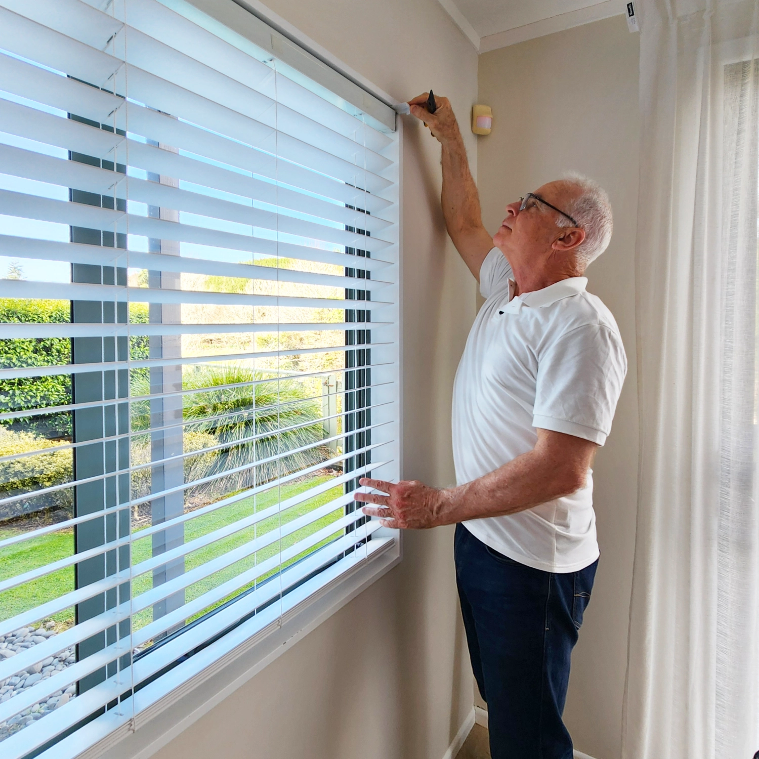 Man adjusting Venetian blind. 