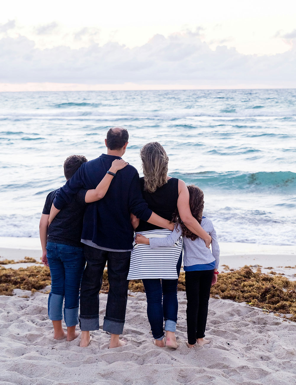 Family at the beach hugging