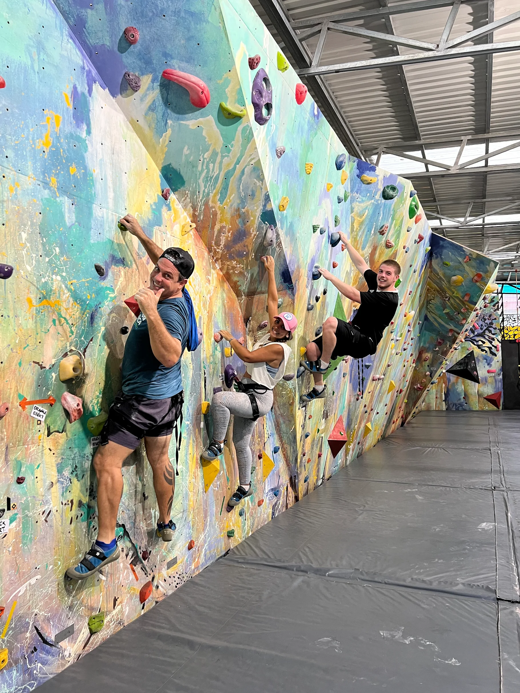 Grupo de personas escalando pared boulder interior en el gimnasio RCCR.
