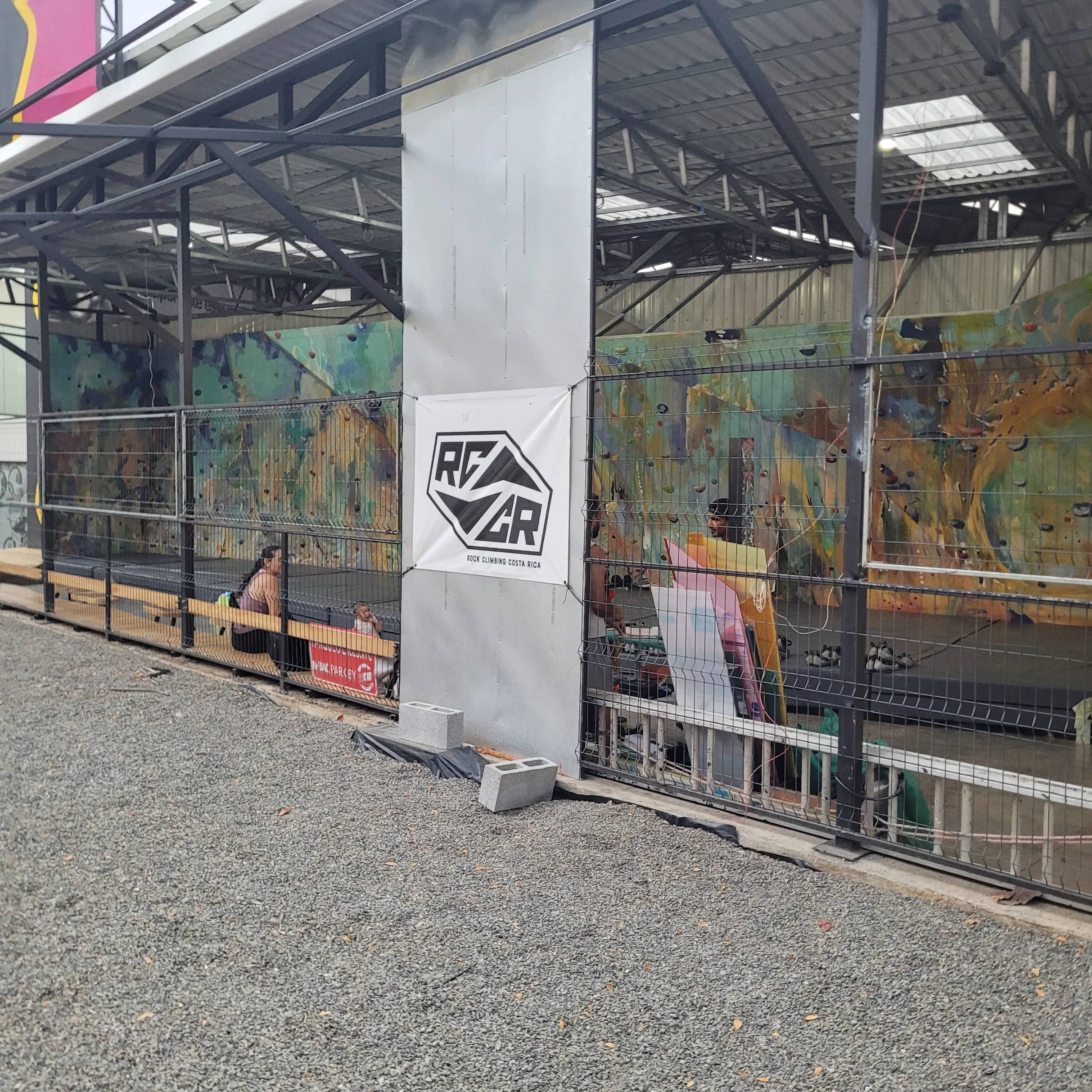 Patio de gimnasio RCCR donde se ve el interior del gimnasio y la pared de boulder.
