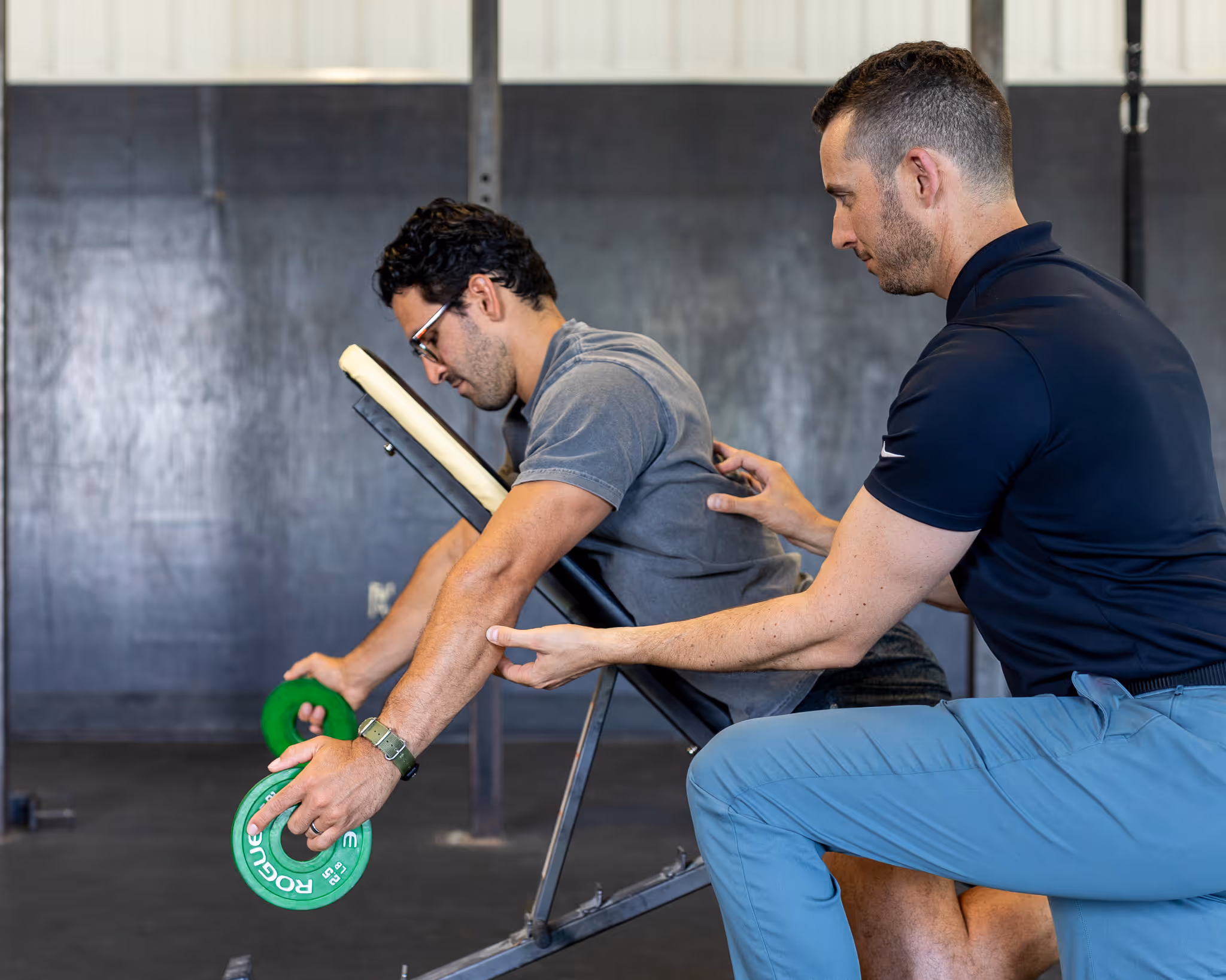Eric working with a patient using weights