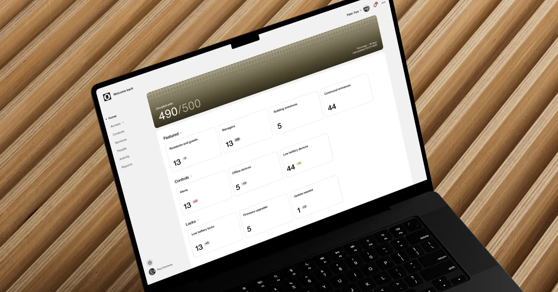 Smart building management dashboard on laptop showing access control, occupancy, and device monitoring for multifamily property operations