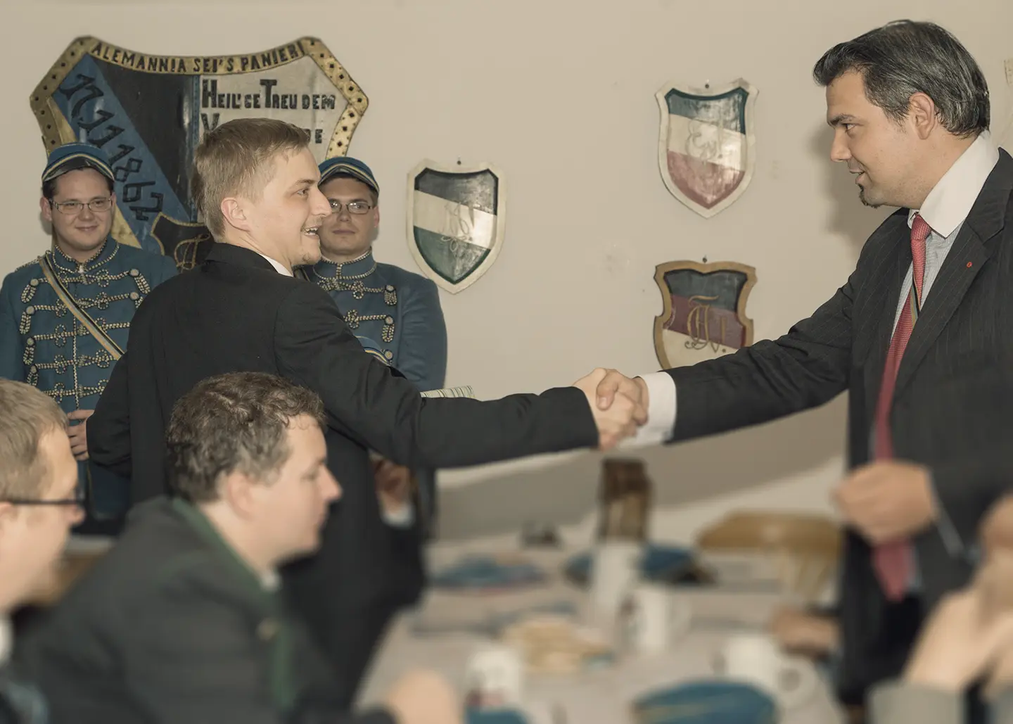 Mitglieder des Linzer Corps geben sich einen Handschlag