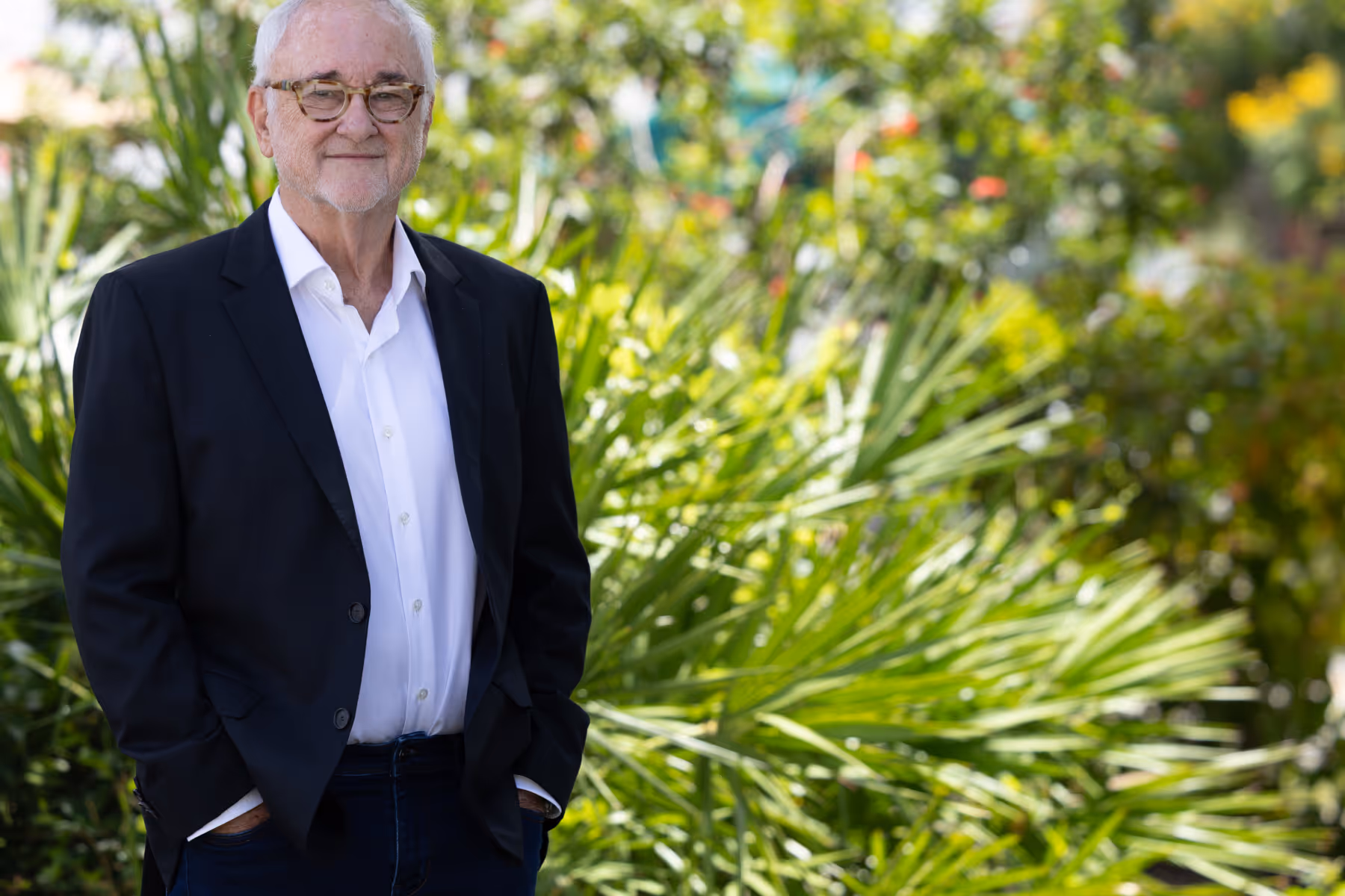 Jeff Anglin in suit jacket, standing in garden setting
