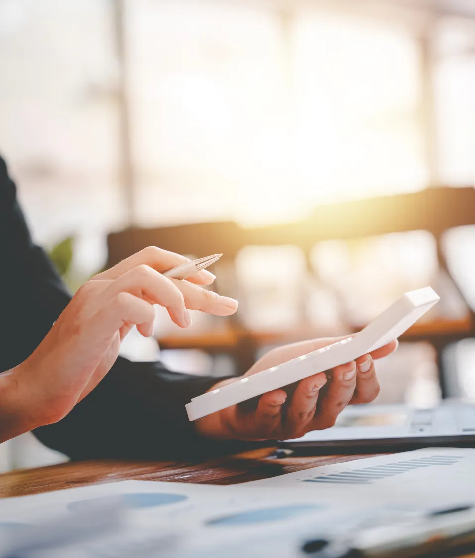 A close up of a pair of handing typing on a calculator