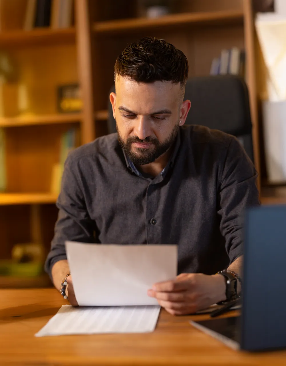 A man sitting at a desk reviewing a doument
