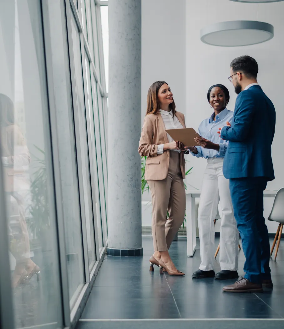 A team of business people discussing in a large glass lobby