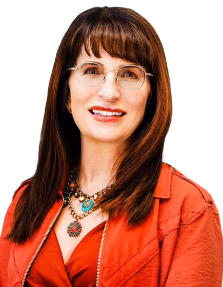 Smiling woman with straight brown hair wearing glasses, a red top, a red jacket, and layered necklaces with colorful pendants.