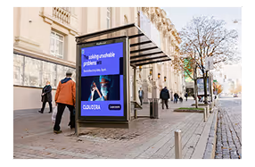 City street bus stop with a CloudEra ad showing a man working on a laptop, text about solving ungradable problems